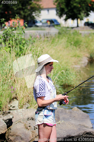 Image of Woman with freckles and hot pants while fishing