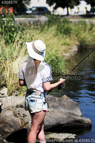 Image of Woman with freckles and hot pants while fishing