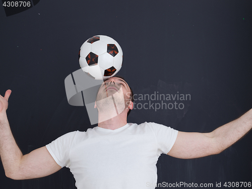 Image of man playing with soccer ball isolated over grey