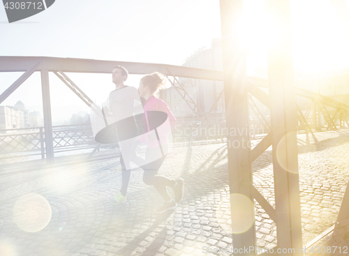 Image of healthy young couple jogging in the city