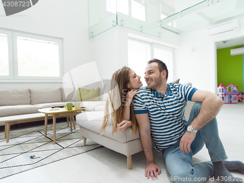 Image of young handsome couple hugging on the sofa