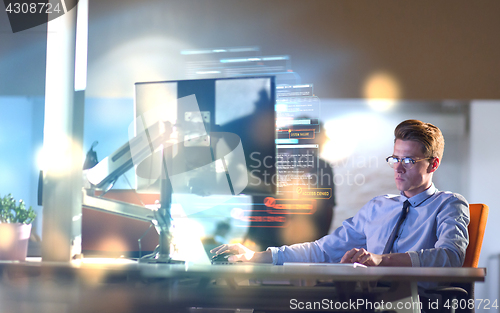 Image of man working on computer in dark office