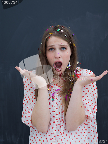 Image of woman blowing confetti in the air isolated over gray