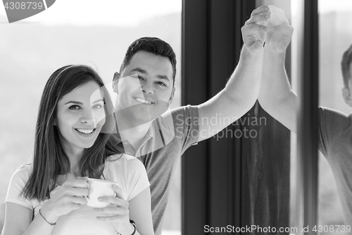 Image of Happy two young lovers standing in living room