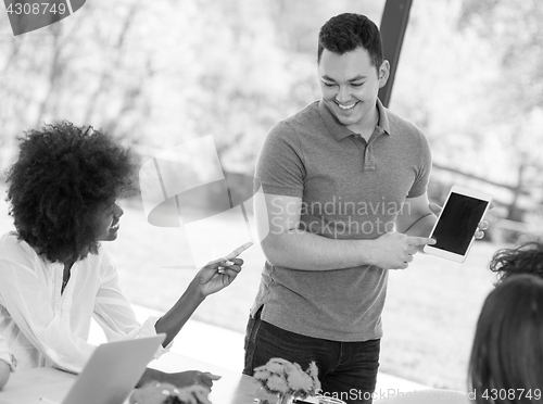 Image of Young businessman with his team at work