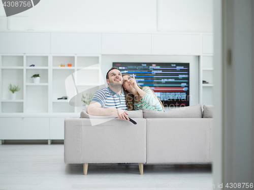 Image of Young couple on the sofa watching television
