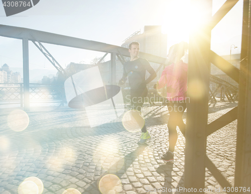 Image of healthy young couple jogging in the city