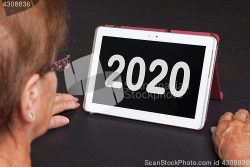 Image of Senior lady relaxing and her tablet - 2020