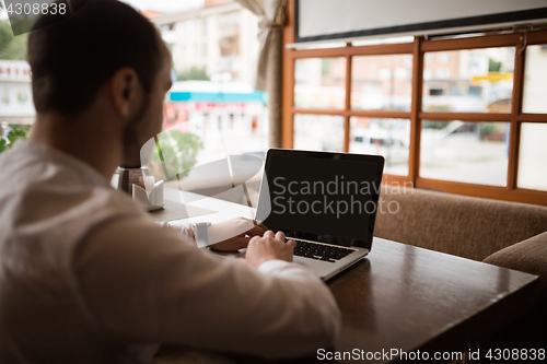 Image of Man is looking at laptop with excitement.