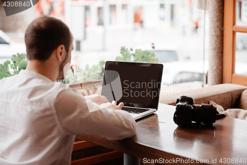 Image of Man is looking at laptop with excitement.