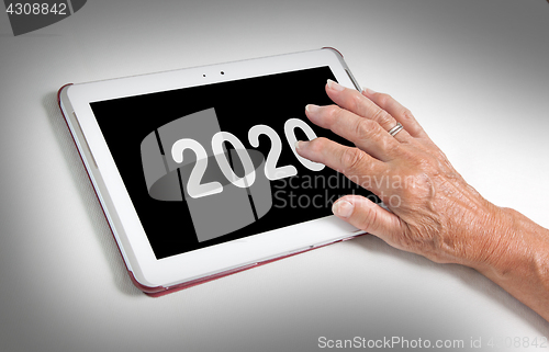 Image of Senior lady relaxing and her tablet - 2020