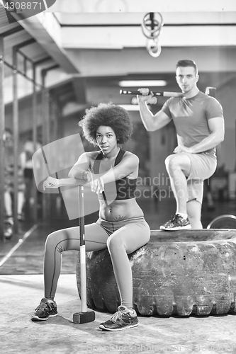 Image of multiethnic couple after workout with hammer