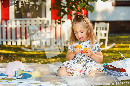 Image of The little girl sitting on green grass