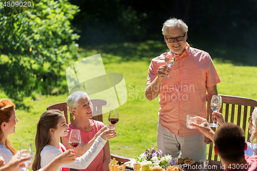 Image of happy family having dinner or summer garden party