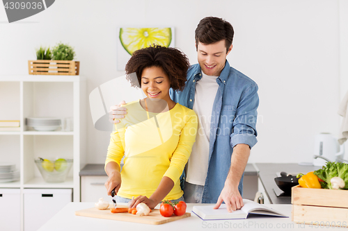 Image of happy couple cooking food at home kitchen