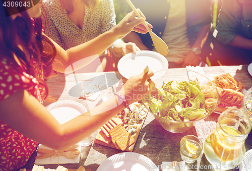 Image of happy friends having dinner at summer party