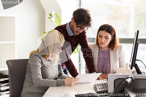 Image of happy business team with papers in office