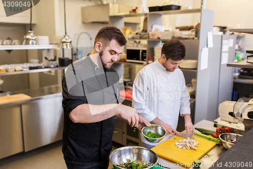 Image of chef and cook cooking food at restaurant kitchen