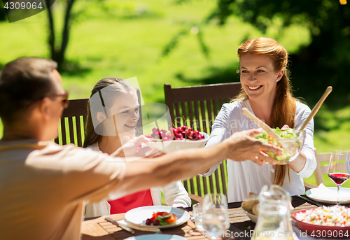 Image of happy family having dinner or summer garden party