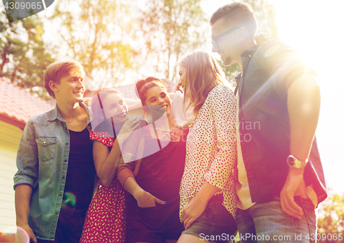 Image of happy teenage friends hugging at summer garden