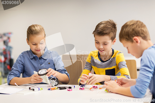 Image of happy children building robots at robotics school