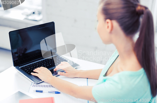 Image of businesswoman with laptop computer in office