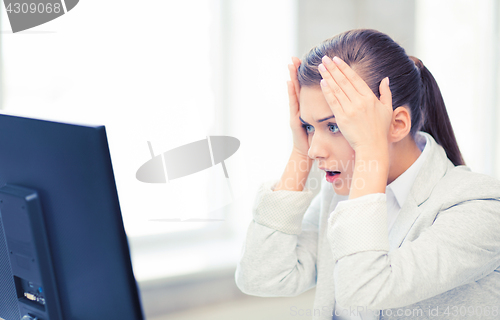 Image of stressed student with computer in office