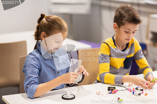 Image of happy children building robots at robotics school