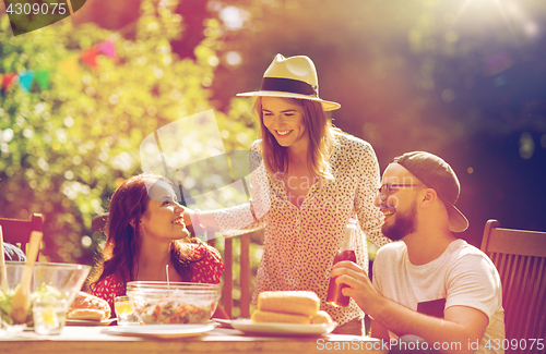 Image of happy friends having dinner at summer garden party