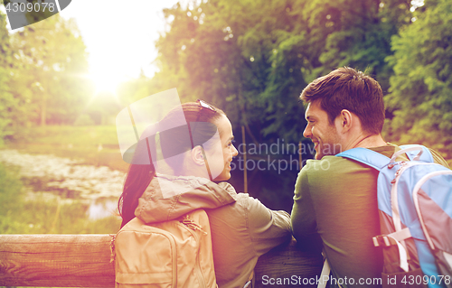 Image of smiling couple with backpacks in nature