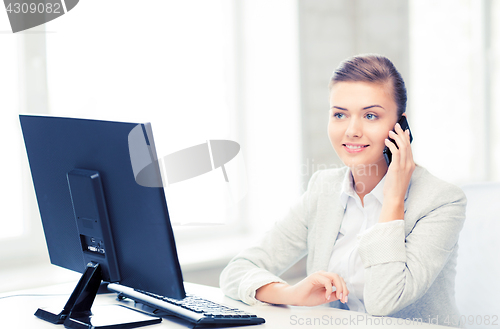 Image of businesswoman with smartphone in office