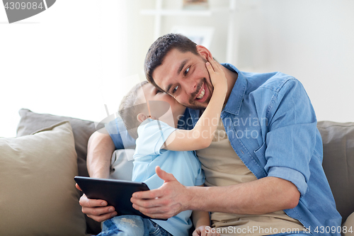 Image of father and son with tablet pc playing at home