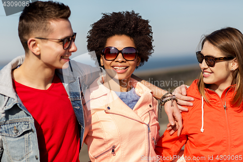 Image of happy teenage friends in shades talking on street