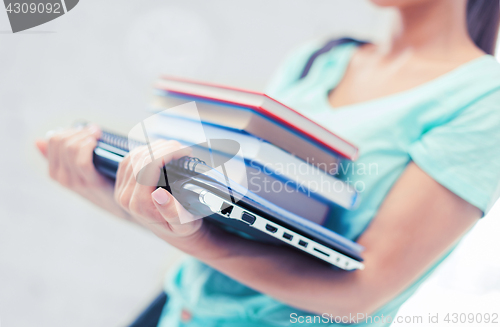 Image of student with books, computer and folders