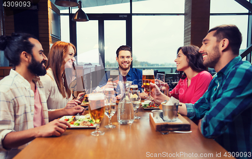 Image of friends dining and drinking beer at restaurant