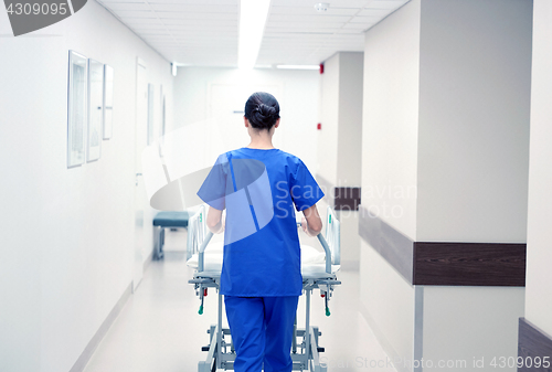 Image of nurse carrying hospital gurney to emergency room