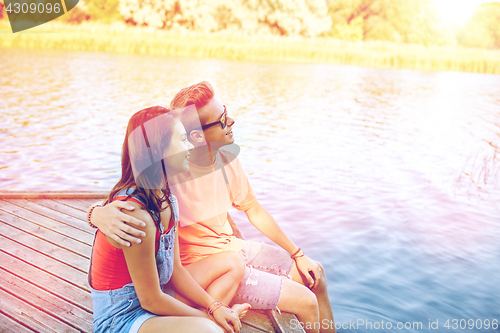 Image of happy teenage couple hugging on river berth