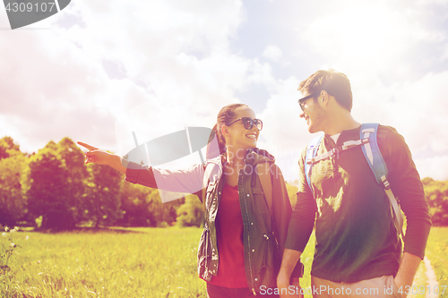 Image of happy couple with backpacks hiking outdoors