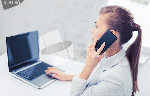 Image of businesswoman with smartphone in office