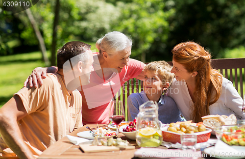 Image of happy family having dinner or summer garden party