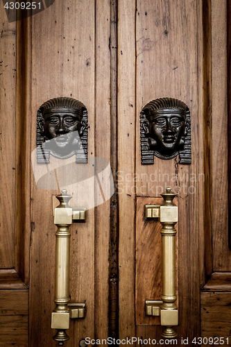 Image of Sphinx heads entrance on wooden door