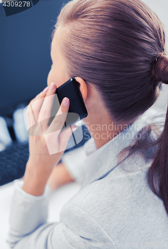 Image of businesswoman with smartphone in office