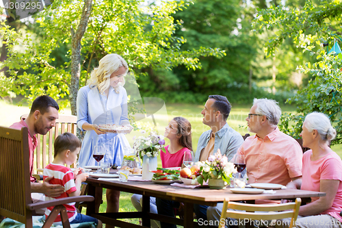 Image of happy family having dinner or summer garden party