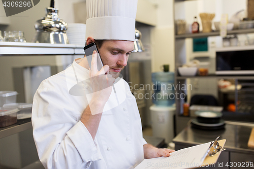 Image of chef calling on smartphone at restaurant kitchen