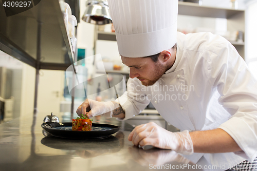 Image of happy male chef cooking food at restaurant kitchen