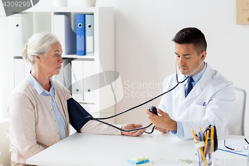 Image of senior woman and doctor with tonometer at hospital