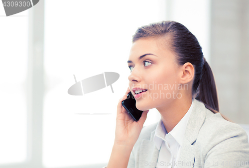 Image of businesswoman with smartphone in office