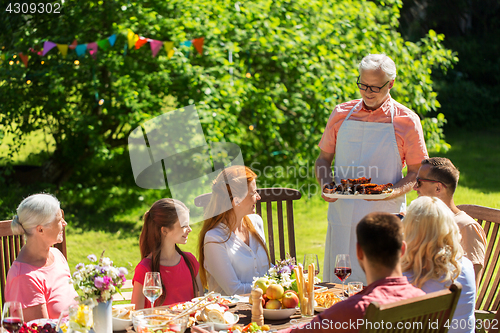 Image of happy family having dinner or summer garden party