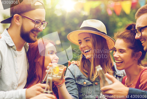 Image of happy friends clinking glasses at summer garden