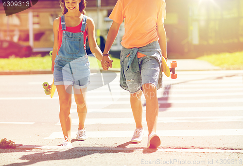 Image of teenage couple with skateboards at city crosswalk